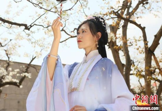 圖為蘭州青年身穿漢服在百年梨園賞景?！「哒?攝