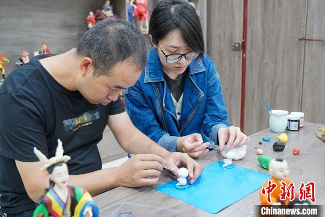<a target='_blank'  data-cke-saved- >中新社</a>記者(右)現(xiàn)場(chǎng)體驗(yàn)面塑制作過(guò)程?！￡悹?zhēng)強(qiáng) 攝