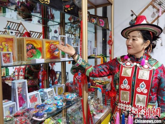 圖為身著民族服飾的隴原巧手展示手工藝品。(資料圖) 徐雪 攝