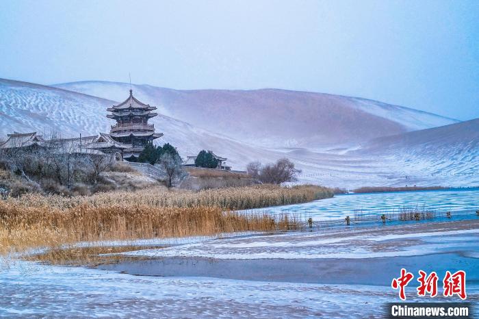 2021年11月28日，雪落鳴沙山月牙泉景區(qū)?！⊥醣筱y 攝