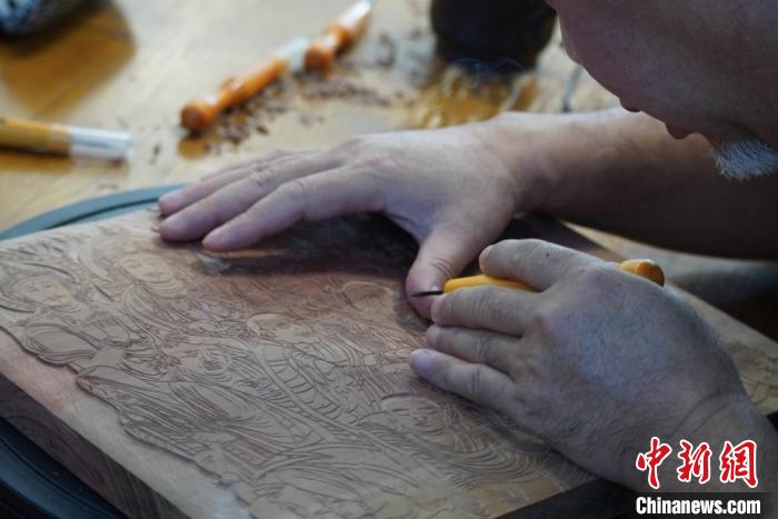 圖為徐晉林湊近木板，近距離制作雕版畫?！【琶赖┰?　攝