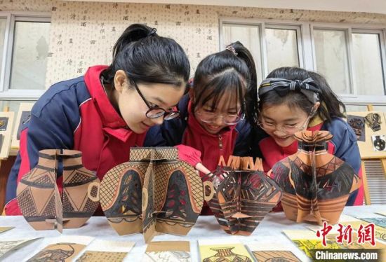 圖為學(xué)生用紙創(chuàng)作的立體彩陶?！⒂裉?攝