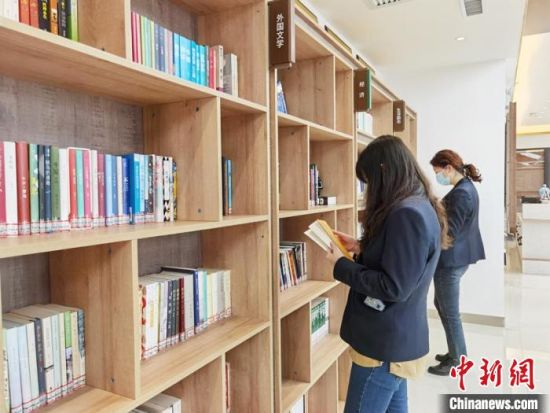 圖為在甘肅公航旅建設(shè)集團有限公司的職工書屋，職工挑選書籍?！⌒煅?攝