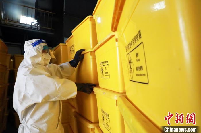 圖為工作人員搬運醫(yī)療廢物專用周轉(zhuǎn)箱?！∥航ㄜ?攝