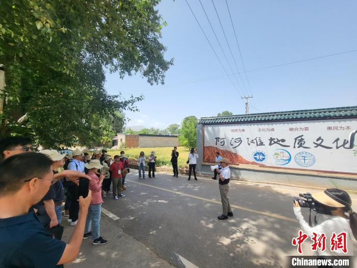 圖為中國地質(zhì)大學(xué)(北京)教授張緒教介紹村落情況?！『衍?攝