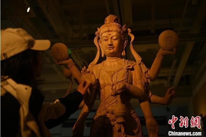 圖為季茂杰觀察自己創(chuàng)作的敦煌木雕。李亞龍 攝</p>
<p>