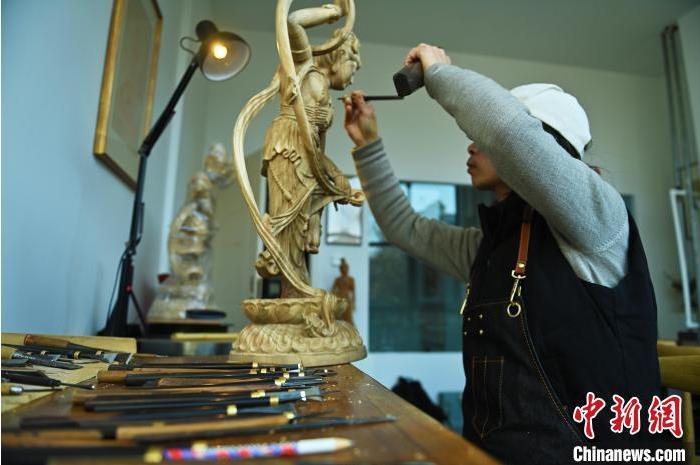 圖為季茂杰進(jìn)行敦煌元素的木雕創(chuàng)作。李亞龍 攝</p>
<p>