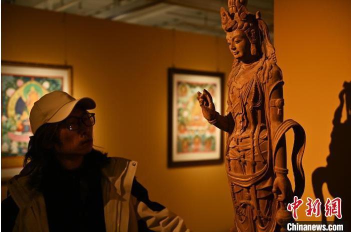 圖為季茂杰觀察自己創(chuàng)作的敦煌木雕。李亞龍 攝</p>
<p>