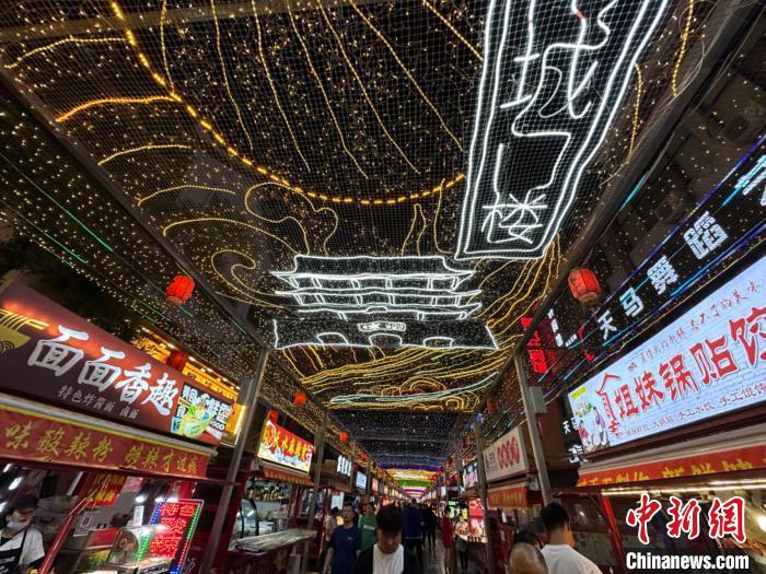 圖為明清街夜市燈光點(diǎn)亮具有武威文化元素的“涼州古城門”彩燈?！〈魑牟?攝</p><p>