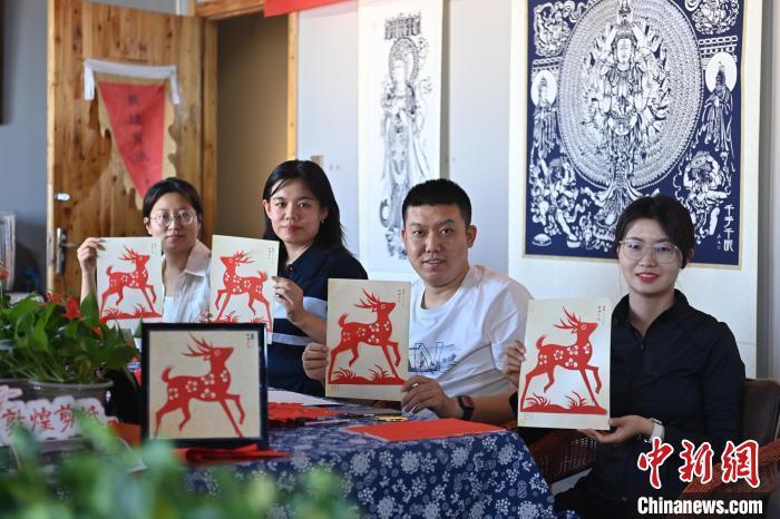 6月6日，在甘肅敦煌青年夜校課程中，青年學(xué)員展示學(xué)習(xí)敦煌非遺剪紙的成果。李亞龍 攝　　