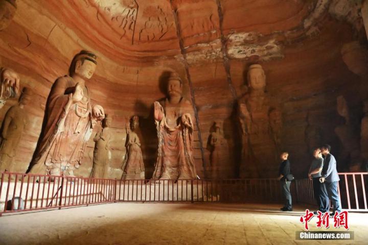 7月15日，游人參觀甘肅省平?jīng)鍪袥艽h百里石窟長(zhǎng)廊中的南石窟寺1號(hào)窟。百里石窟長(zhǎng)廊位于涇川縣境內(nèi)，由512個(gè)石窟、5眼窟中石井組成，現(xiàn)存王母宮石窟、鳳凰山石窟、南石窟寺、丈八寺石窟、羅漢洞石窟、太山寺石窟等規(guī)模較大的石窟群，還有數(shù)量眾多的小石窟群。南石窟寺開(kāi)鑿于北魏永平三年，其中1號(hào)窟屬于大型七佛窟，七佛高達(dá)6米。中新社記者 李亞龍 攝