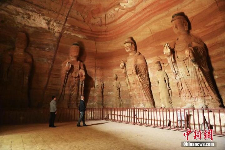 7月15日，游人參觀甘肅省平?jīng)鍪袥艽h百里石窟長(zhǎng)廊中的南石窟寺1號(hào)窟。百里石窟長(zhǎng)廊位于涇川縣境內(nèi)，由512個(gè)石窟、5眼窟中石井組成，現(xiàn)存王母宮石窟、鳳凰山石窟、南石窟寺、丈八寺石窟、羅漢洞石窟、太山寺石窟等規(guī)模較大的石窟群，還有數(shù)量眾多的小石窟群。南石窟寺開(kāi)鑿于北魏永平三年，其中1號(hào)窟屬于大型七佛窟，七佛高達(dá)6米。中新社記者 李亞龍 攝