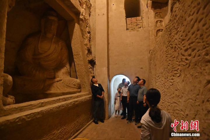7月15日，游人參觀甘肅省平?jīng)鍪袥艽h百里石窟長(zhǎng)廊中的王母宮石窟。百里石窟長(zhǎng)廊位于涇川縣境內(nèi)，由512個(gè)石窟、5眼窟中石井組成，現(xiàn)存王母宮石窟、鳳凰山石窟、南石窟寺、丈八寺石窟、羅漢洞石窟、太山寺石窟等規(guī)模較大的石窟群，還有數(shù)量眾多的小石窟群。王母宮石窟又名千佛洞，該窟設(shè)計(jì)宏大，造像生動(dòng)，窟內(nèi)擁有造像數(shù)百尊，是較為珍貴的佛教文化歷史遺存。中新社記者 李亞龍 攝</p>
<p>