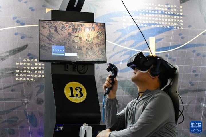 7月22日，游客借助VR設(shè)備沉浸式游覽莫高窟第285窟虛擬場景。新華社記者 郎兵兵 攝